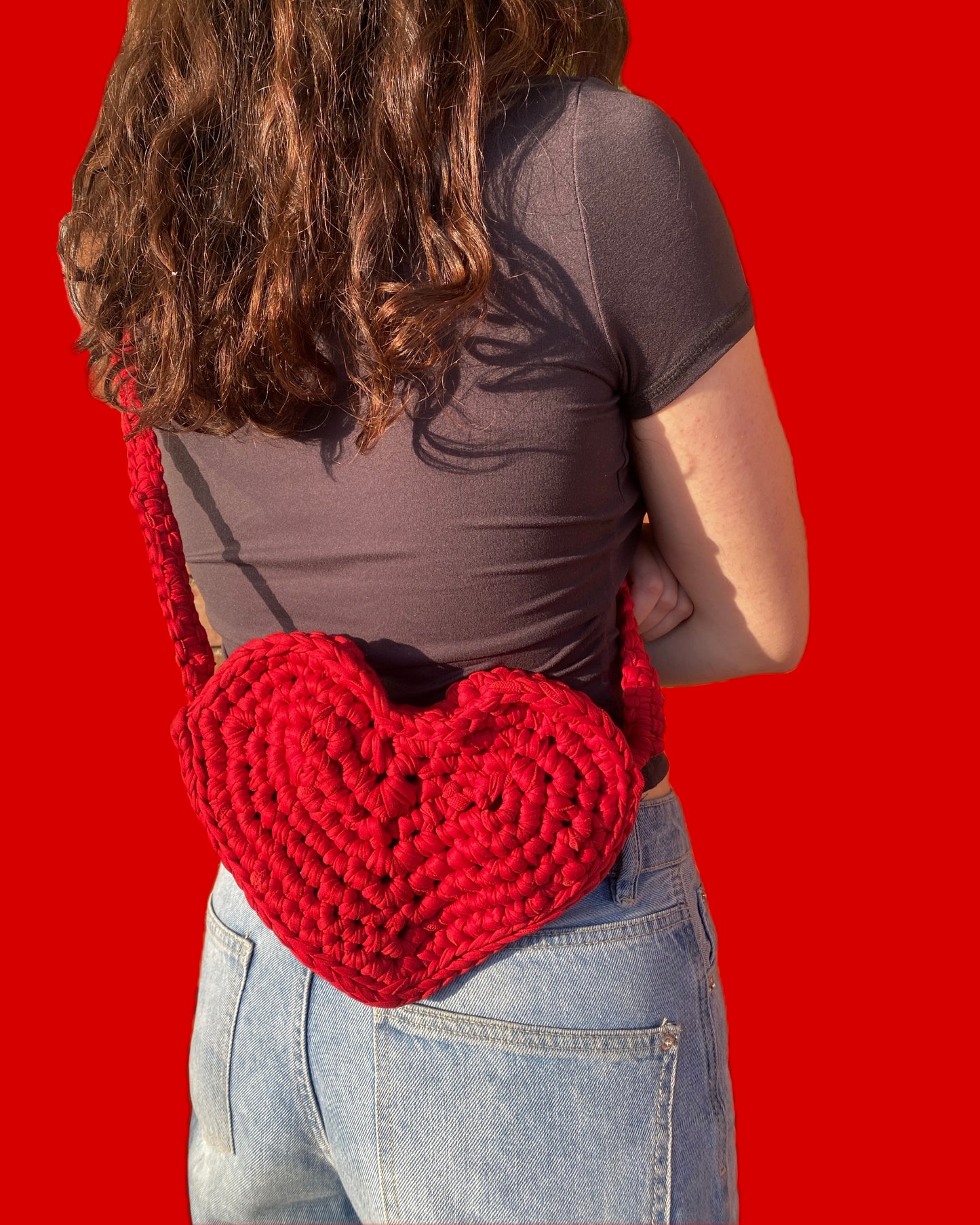 Chica de espaldas con un bolso de ganchillo de la colección ciclo Santa Valentina de Teixint Cicles
